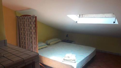 斯佩隆加的住宿－DANYGIO - MANSARDA SPERLONGA，一间卧室配有一张床和天窗