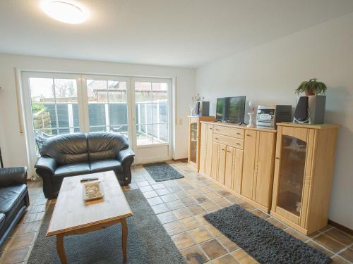 un salon avec un canapé et une table dans l'établissement Ferienhaus Gerth, FeWo Vermittlung Nordsee, à Dangast