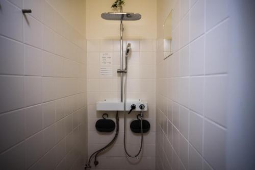 a shower in a white tiled bathroom at A7 Apartments in Komárno