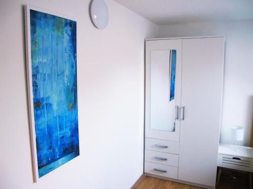 una stanza con un armadietto bianco e un dipinto sul muro di Apartment Ivna a Pola (Pula)