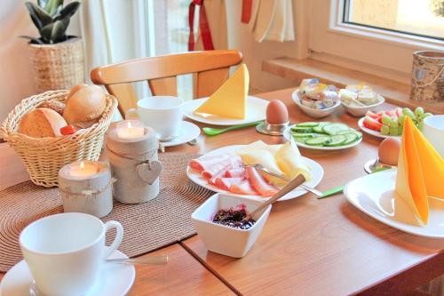 a table with food and cups and plates of food at Pension An der Kamske, DZ 3 in Lübbenau