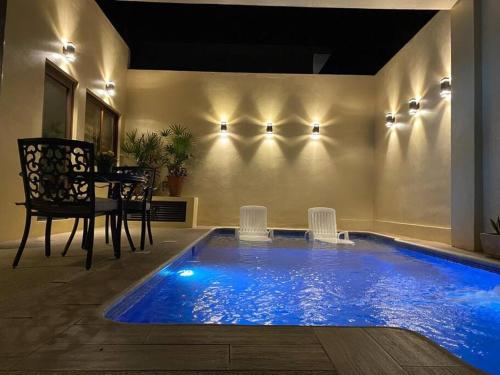 a swimming pool in a house with a table and chairs at Casita con Alberca en San Fran. in San Francisco