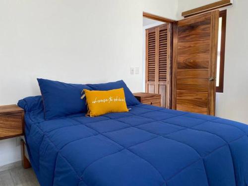 Casita con Alberca en San Fran. في سان فرانسيسكو: سرير ازرق ومخدة صفراء في غرفة النوم
