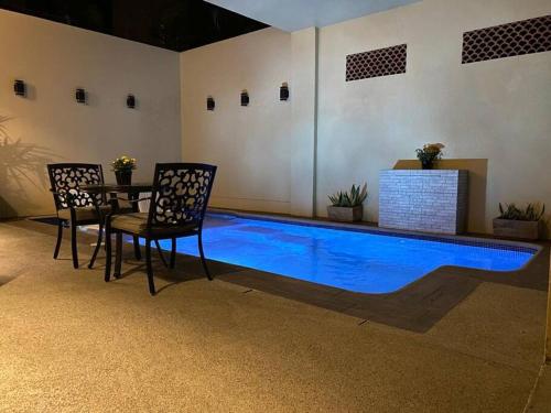 a swimming pool in a room with a table and chairs at Casita con Alberca en San Fran. in San Francisco
