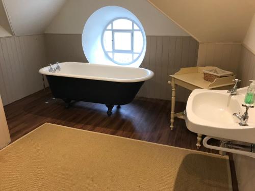 ein Badezimmer mit einer großen Badewanne und einem Waschbecken in der Unterkunft The Bothy, Gallin, Glenlyon, Perthshire 