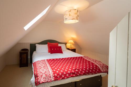 Un dormitorio con una cama roja y blanca en un ático en The Bothy, Gallin, Glenlyon, Perthshire, en Bridge of Balgie