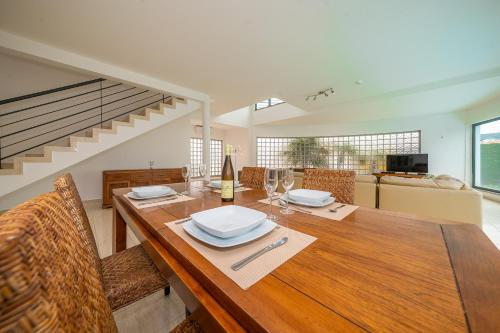 a dining room with a wooden table with wine glasses at RT Palmela Village in Palmela