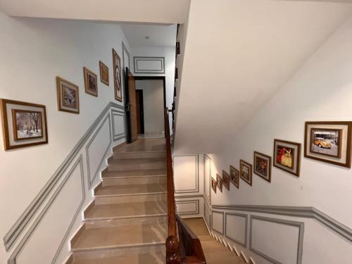 a staircase in a house with pictures on the walls at Sunset BnB in Karachi
