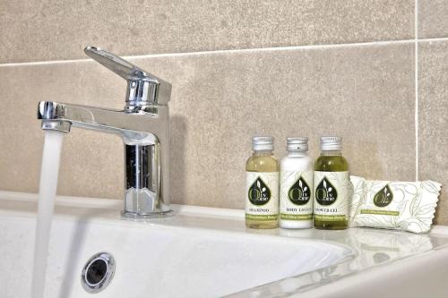 un lavandino in bagno con due bottiglie di sapone di [Idromassaggio & BBQ]wifi, relax e private parking a Sirolo