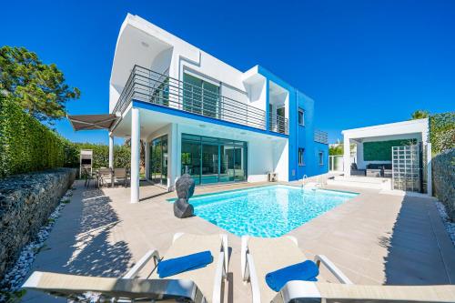 a villa with a swimming pool and a house at RT Palmela Village in Palmela