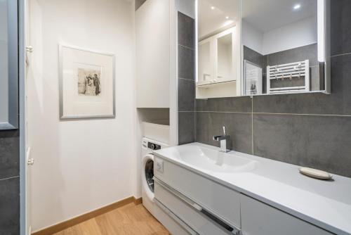 a white bathroom with a sink and a mirror at Baie Roquebrune, Balcon Vue Mer, Parking Gratuit - AO in Roquebrune-Cap-Martin