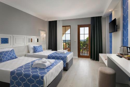 a hotel room with two beds and a kitchen at Euphoria Barbaross Beach Resort in Kızılot