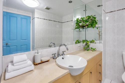 a bathroom with a white sink and a blue door at Oasis in the Heart of the City in Cairns