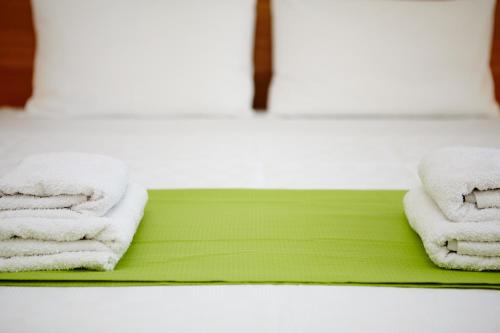 two towels on a green tray in a bathroom at Amarandos Sea View Apartments in Vokaria