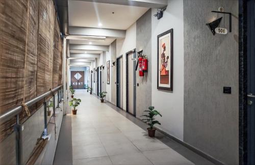 a corridor of a building with potted plants at HOTEL THE PARKER INN By KBNT GROUP in Surat