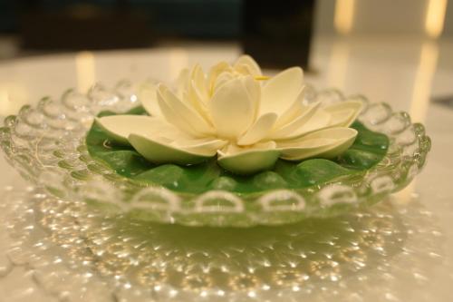 a glass bowl with a flower on a table at HOTEL THE PARKER INN By KBNT GROUP in Surat