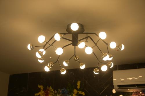 a chandelier with lights hanging from the ceiling at HOTEL THE PARKER INN By KBNT GROUP in Surat