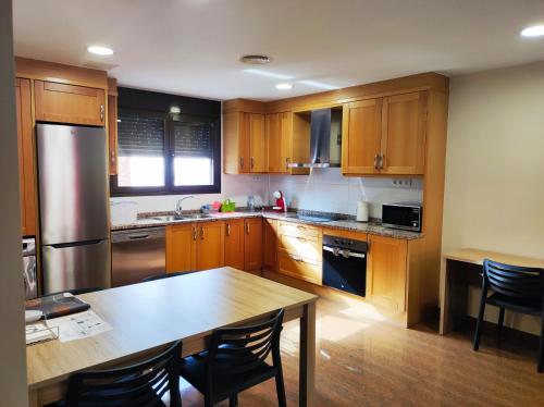 a kitchen with wooden cabinets and a table with chairs at Ancla Spaces nuevo apt cerca del mar, sin vistas in Vinarós
