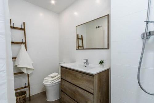 y baño con lavabo, espejo y aseo. en Acojedor y exclusivo loft by Lofties, en Terrassa