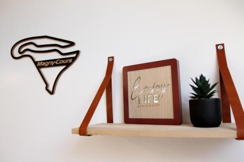 a shelf with a picture and a cactus on it at Le Circuit - Tout simplement: confort! in Cosne Cours sur Loire