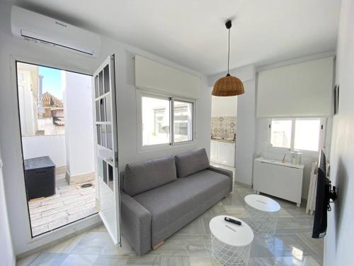 a living room with a couch and a table at Buhardilla en calle Ancha, pleno centro in Sanlúcar de Barrameda