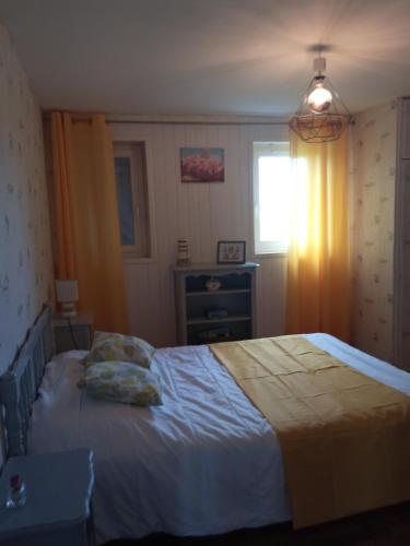 a bedroom with a bed and a window at Les Hortensias 26 in Saint-Laurent-sur-Mer