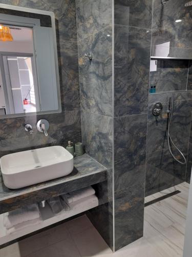 a bathroom with a sink and a shower at Anxhelos Hotel in Himare