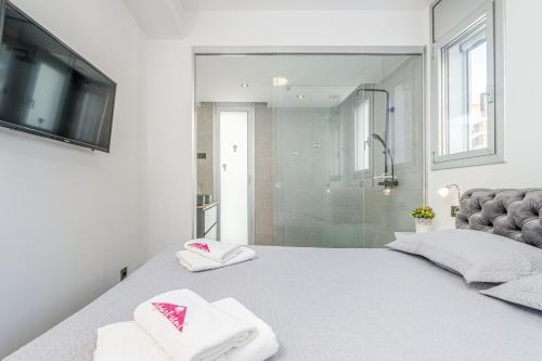 ein Schlafzimmer mit einem Bett mit Handtüchern und einer Dusche in der Unterkunft Apart-rent Apartamento Av Platja Santa Margarita 2010 in Roses