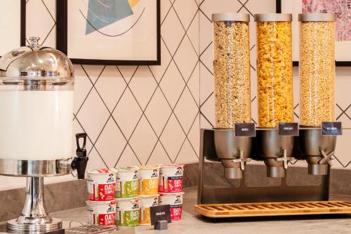 a kitchen counter with three tall containers of food at Hampton By Hilton London City in London