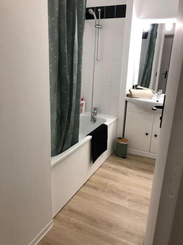 une salle de bain avec une baignoire, un lavabo et une douche dans l'établissement Appartement F2 calme et élégant, à Équemauville