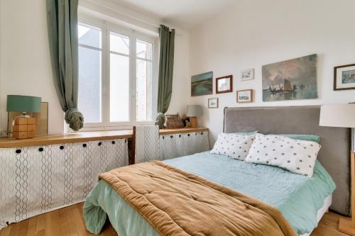sypialnia z łóżkiem i oknem w obiekcie Appartement de charme en centre-ville pour 6 pers. w mieście Nantes
