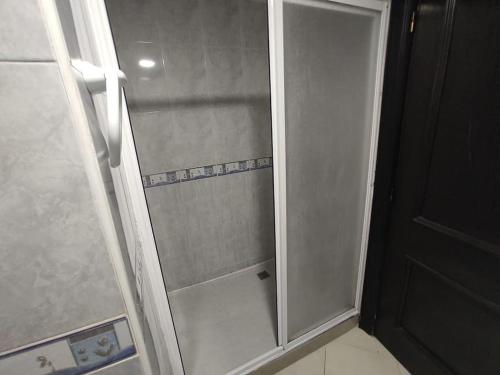 een douche met een glazen deur in de badkamer bij Marina Beach (3 Swimming pools, Direct Access to the Beach) in Mohammedia