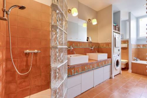 łazienka z prysznicem, 2 umywalkami i pralką w obiekcie Appartement de charme en centre-ville pour 6 pers. w mieście Nantes