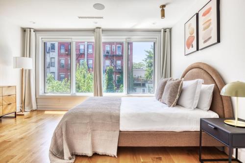 - une chambre avec un lit et une grande fenêtre dans l'établissement 2BR Gowanus Townhouse w WD nr Prospect Park NYC-883, à Brooklyn