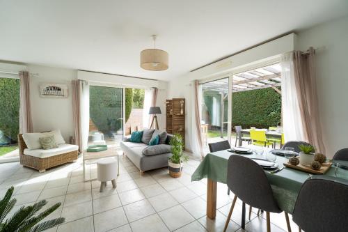 un salon avec une table et un canapé dans l'établissement La Perlière - Avec piscine proche du golf, à La Teste-de-Buch