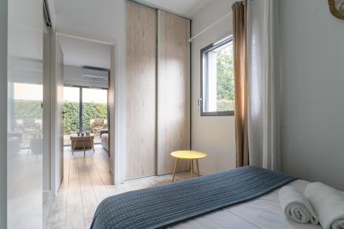 a bedroom with a bed and a sliding glass door at Côté Port - Appt sortie privée vers le port in Arcachon