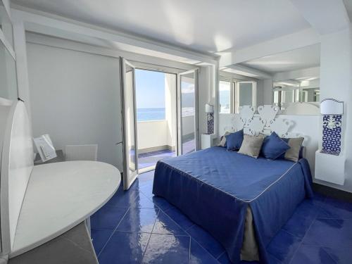 una camera con letto blu e vista sull'oceano di Albergo Da Carmine a Castellabate