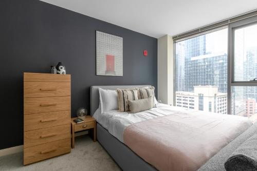 a bedroom with a bed and a dresser and a window at Loop Studio w Pool Gym nr Financial District CHI-228 in Chicago