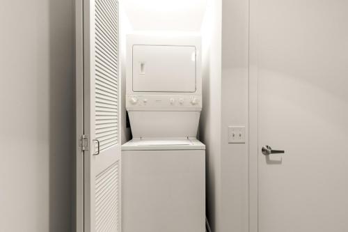 a small white refrigerator in a room with a door at Loop Studio w Pool Gym nr Financial District CHI-228 in Chicago