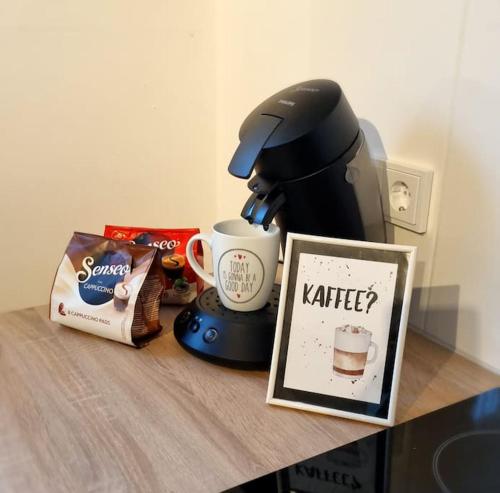 a table with a coffee maker and a cup of coffee at Ruhige, modern eingerichtete 2 Zimmer Wohnung im Untergeschoss eines Zweifamilienhauses in Hildrizhausen