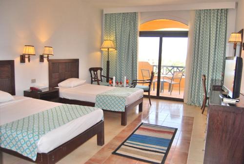 a hotel room with two beds and a balcony at Blend Elphistone Resort Marsa Alam in Abu Dabab