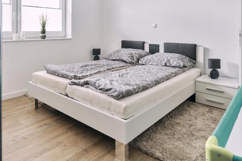 1 cama blanca en un dormitorio blanco con colchón en Harener Hafentraum- 90qm Wohnung mit 40qmTerrasse-kostenloses parken- nähe Schloss Dankern en Haren