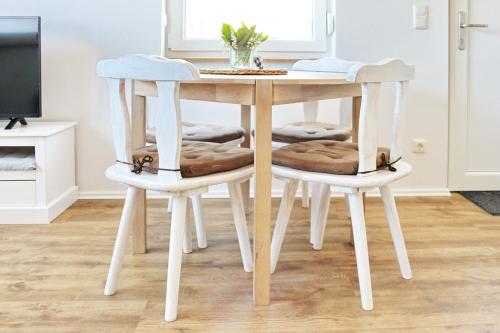 呂貝瑙的住宿－Ferienwohnung Lischka，一张桌子,桌子上有两把白色的椅子,桌子有桌子,