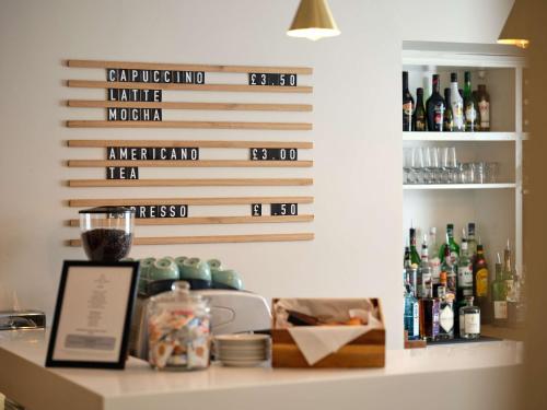 a bar with bottles of alcohol on a wall at Linton Lodge a BW Signature Collection Hotel in Oxford