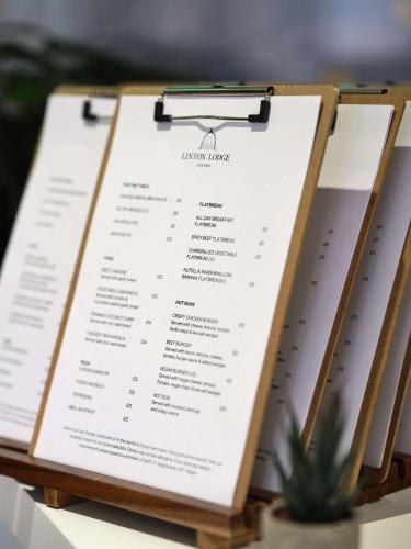 a menu on a table with a plant at Linton Lodge a BW Signature Collection Hotel in Oxford