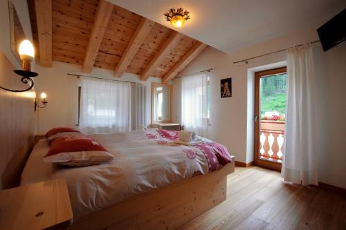 a bedroom with a large bed with a window at Rifugio Palafavera in Val di Zoldo