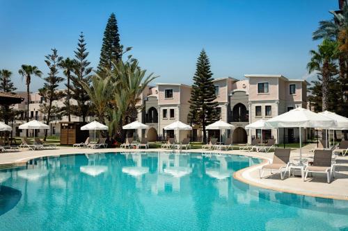 a large swimming pool with chairs and umbrellas at Euphoria Barbaross Beach Resort in Kızılot