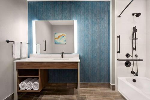 W łazience znajduje się umywalka, lustro i wanna. w obiekcie La Quinta Inn & Suites by Wyndham Del Rio w mieście Del Rio