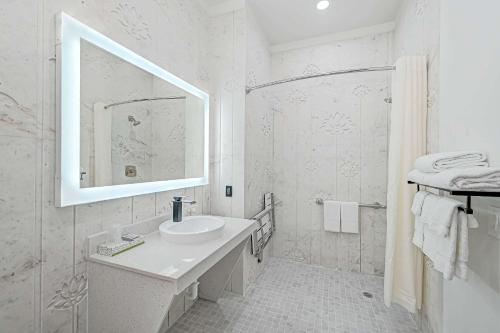 a white bathroom with a sink and a mirror at Comfeeni Inn and Suites in Houston