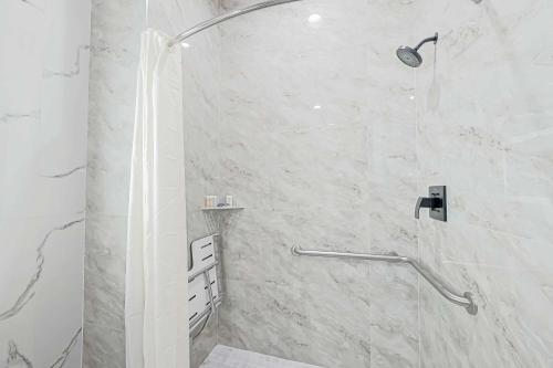 a bathroom with a shower with a glass door at Comfeeni Inn and Suites in Houston
